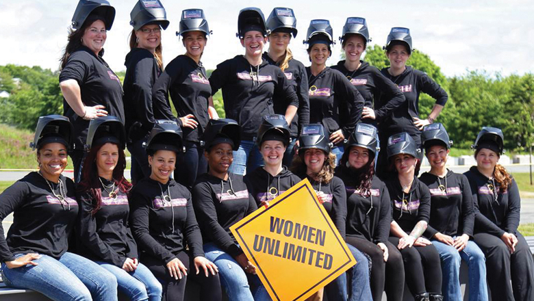 Group of women holding a sign that reads women unlimited